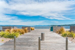 A wooden boardwalk leading to a dock with a view of a lake and mountains in the distance. - A stones throw to lake and town (Taupō)