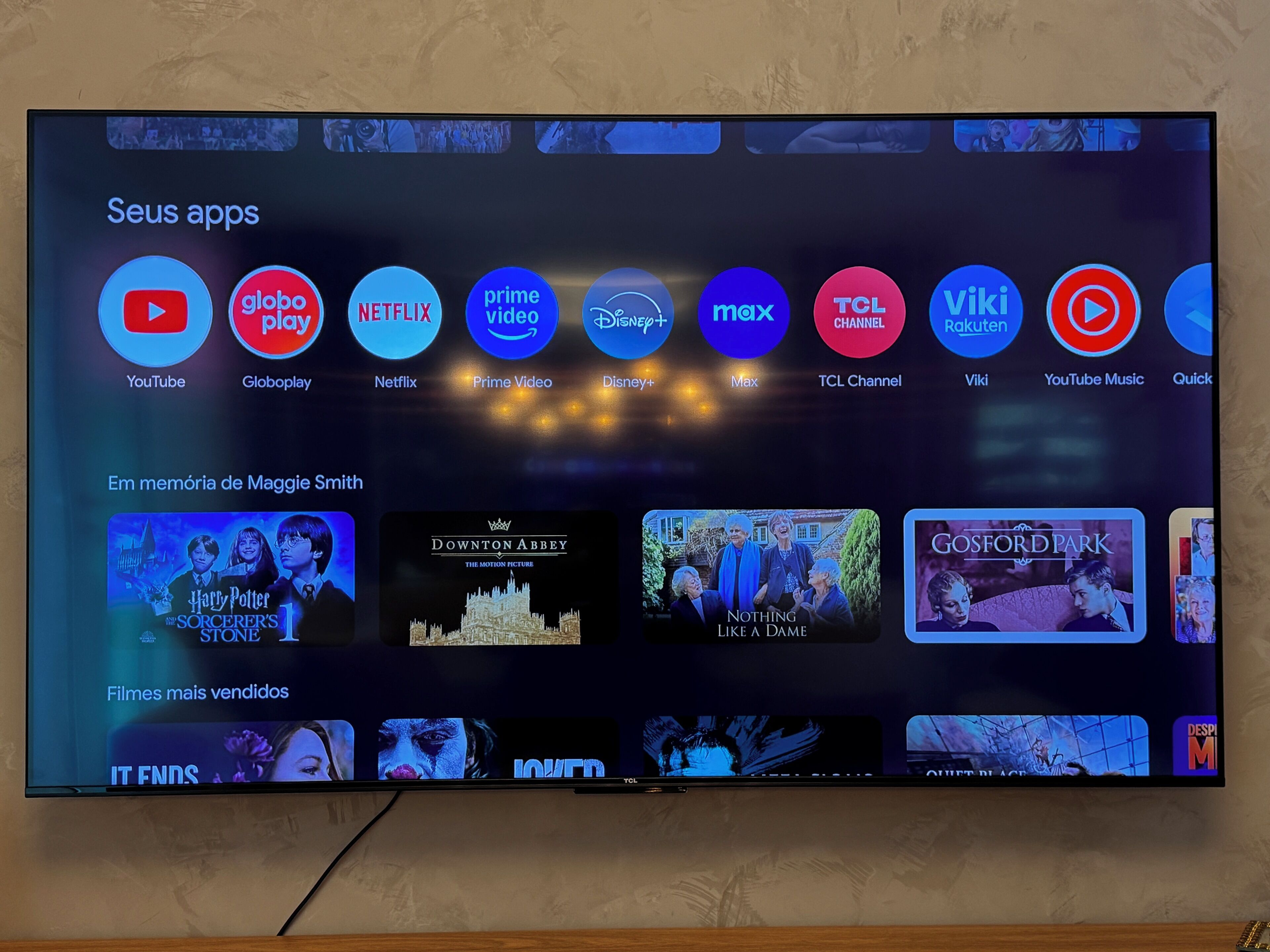Una pantalla de televisión mostrando la interfaz de un servicio de streaming, con varios iconos de aplicaciones y miniaturas de películas.
