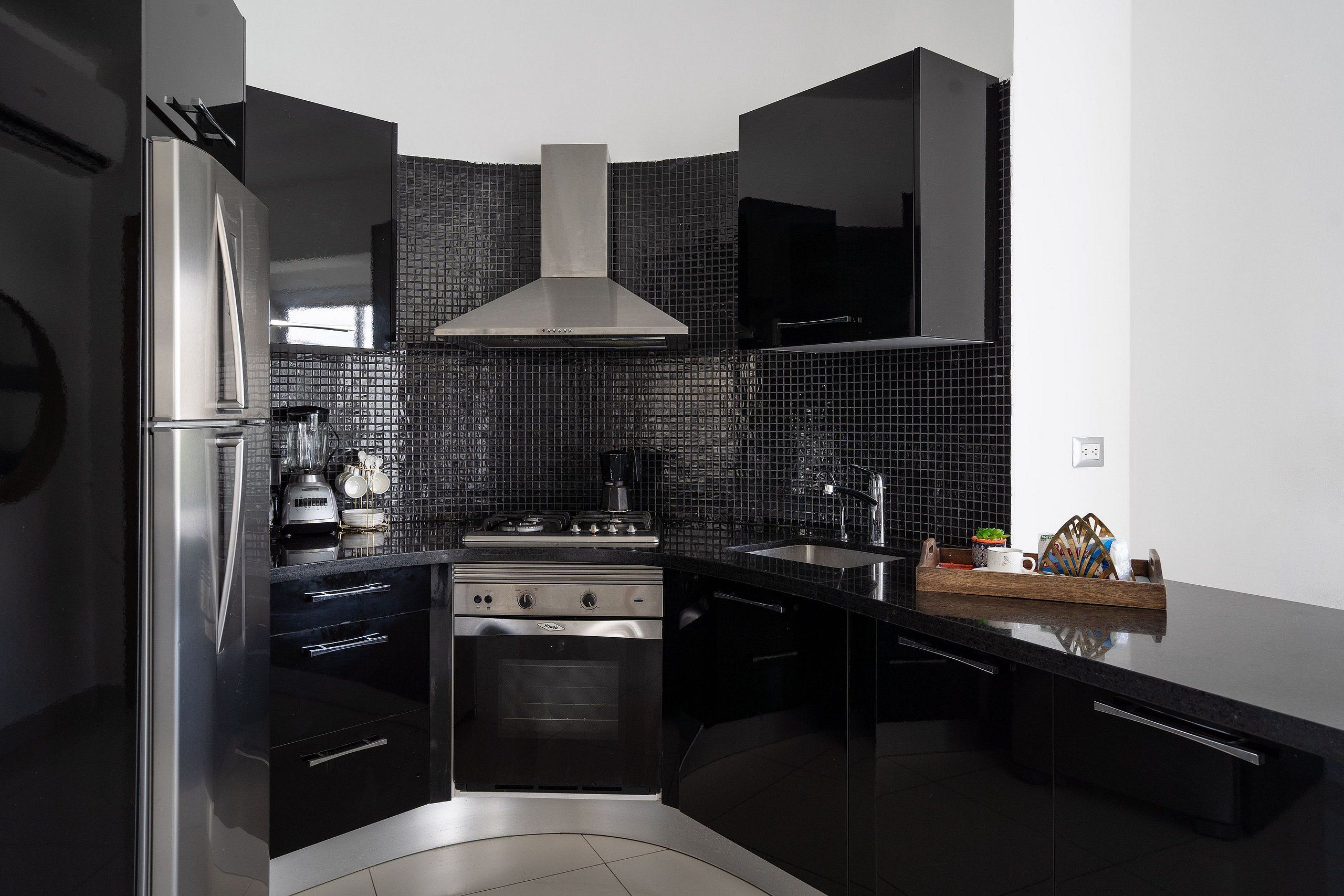 A modern kitchen with a stainless steel refrigerator, a stove, and a sink.