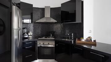 A modern kitchen with a stainless steel refrigerator, a stove, and a sink.