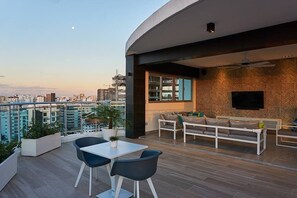 A modern apartment with a balcony, a dining area, and a living room with a TV. - Torre Armonia 24 (Santo Domingo)