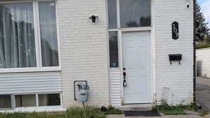 A single-story house with a white exterior, a front door, and a mailbox. - Main Floor Unit (Richmond Hill)
