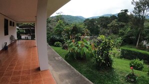 Un espacio al aire libre techado con un patio, una mesa pequeña y sillas.