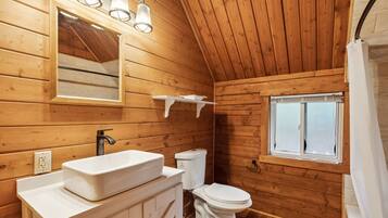 Tina con regadera, toallas, jabón, shampoo