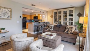 A modern living room with a sofa, two armchairs, a coffee table, and a kitchen in the background. - Cumberland River Views, Walk to Broadway, Downtown & Stadium Rockin' Riverfront (Nashville)