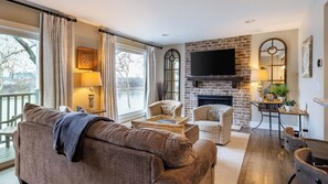 Un salón acogedor con chimenea, asientos cómodos y un televisor grande.