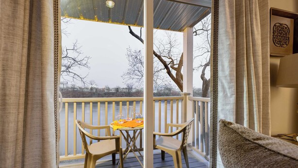 A balcony with a table and chairs, a view of trees, and a railing. - Cumberland River Views, Walk to Broadway, Downtown & Stadium Rockin' Riverfront (Nashville)