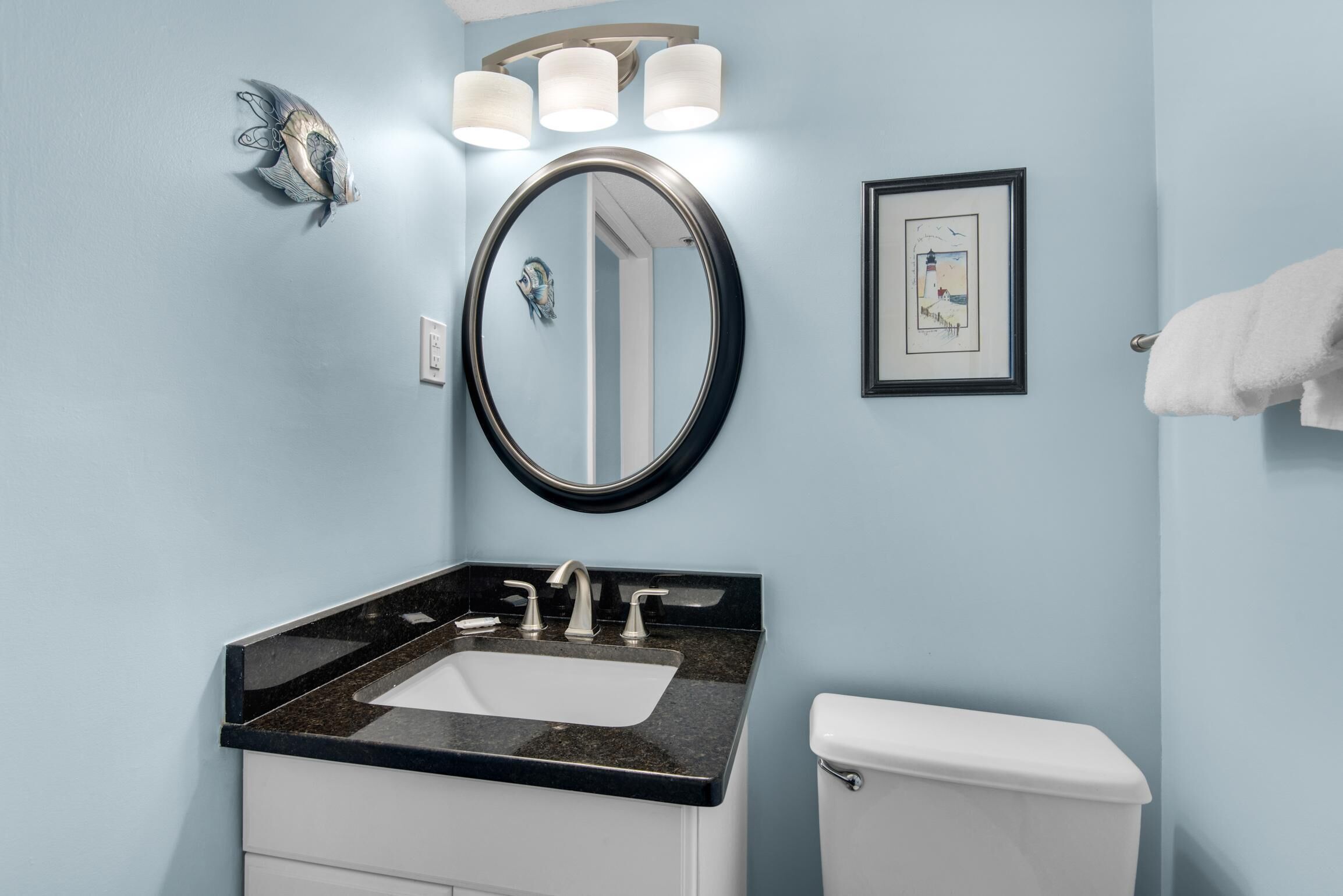 A bathroom with a sink, mirror, and toilet.