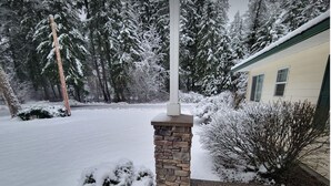 Un paysage enneigé avec un pilier de pierre et une maison.