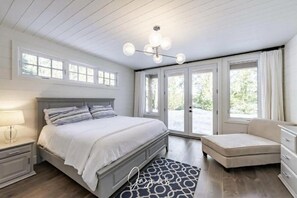 Ein Schlafzimmer mit Bett, Nachttisch, Schminktisch und Blick durch die Tür.