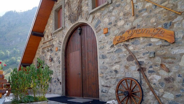 A stone building with a wooden door and a sign reading "La Grange". - LA GRANGE - 2 VAST CHALET APARTMENTS (70m2) - ALPE D'HUEZ ACCESS (Vaujany)