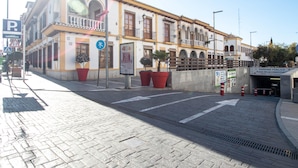 A historic building with a balcony, large potted plants, and a pedestrian crossing sign. - New, beautiful charming apartment. (Armilla (Granada))