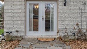 Ein weißes Backsteinhaus mit doppeltürigem Eingang, Fußmatte und Kiesweg.