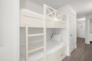 A bunk bed with a ladder, a bedside drawer, and a door in a hallway. - Turtle Cove @ Calypso Resort 3-508, Beach view, Balcony (Panama City Beach)