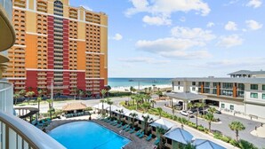 Un hotel con piscina, vista al mar y un muelle.