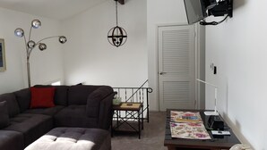 A living room with a sectional sofa, a small table, a floor lamp, and a ceiling light fixture. - Grand Rapids-Kentwood is close to DT and the airport. (Kentwood)