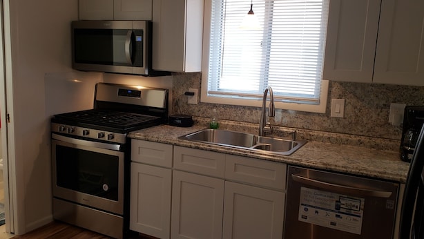A compact kitchen with a microwave, stove, oven, sink, and dishwasher. - Grand Rapids-Kentwood is close to DT and the airport. (Kentwood)