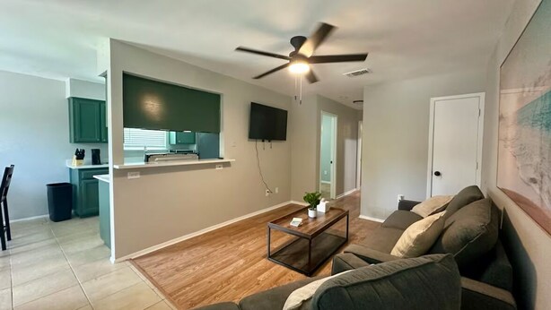 Un salon moderne avec un canapé, une table basse et un ventilateur de plafond.