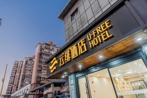 Un hôtel avec une enseigne indiquant « U-FREE HOTEL » et une entrée bien visible.