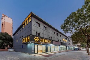 Et hotel med en moderne facade, flere etager og tydelig skiltning.
