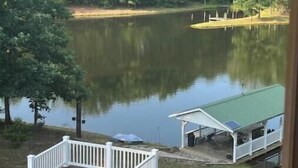 Une terrasse au bord du lac, dotée d’un espace salon couvert et d’un petit bâtiment surmonté d’un toit végétalisé.