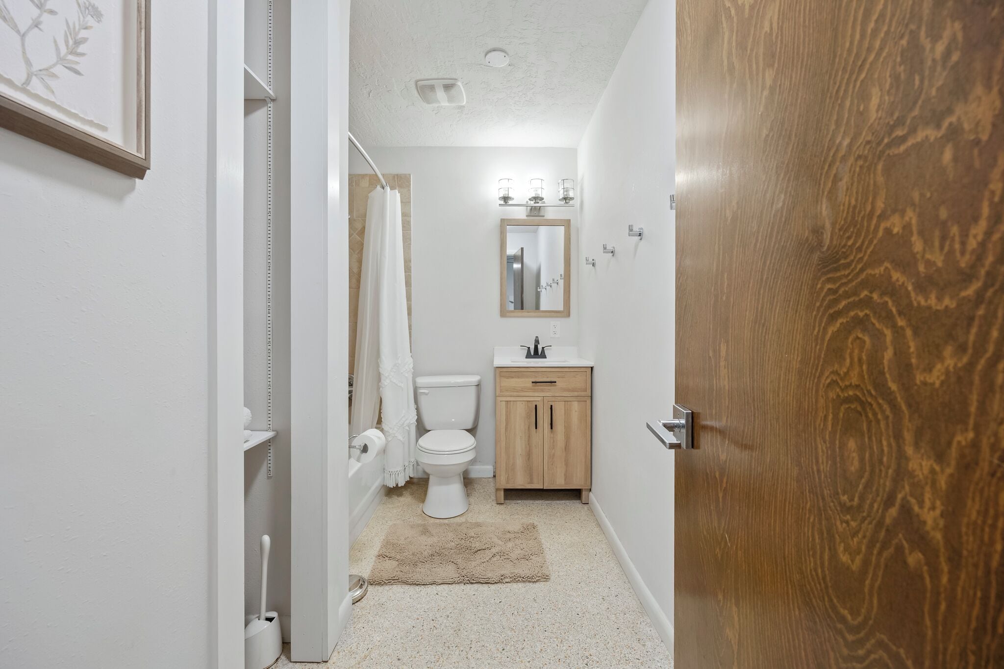 Een kleine badkamer met toilet, wastafel en spiegel.