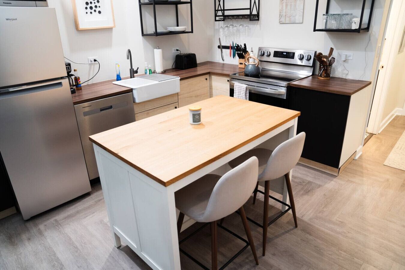 A modern kitchen with a built-in island, stainless steel appliances, and a wooden countertop.