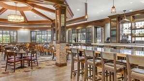 A spacious restaurant with high ceilings, large windows, and a bar area. - Escape to Paradise: Your Family Adventure Awaits- Marriott's Grande Vista- 2 Bd (Orlando)