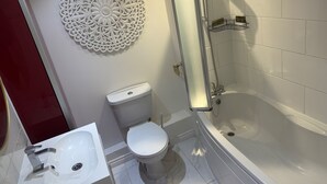 A bathroom with a toilet, sink, and bathtub. - Stylish Apartment in Chafford Hundred (Grays)