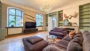 A living room with a television, sofas, a chandelier, and bookshelves. - Nice home in Ekeby with WiFi (Ekeby)
