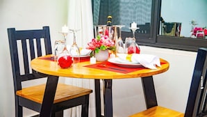 A dining table with a vase of flowers, candles, and a bottle of water. - Loft VIIM | Les Ferys du lac (Ouidah)