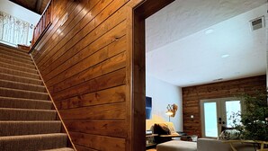 Una escalera de madera que conduce a una sala de estar con un sofá y una mesa de centro.