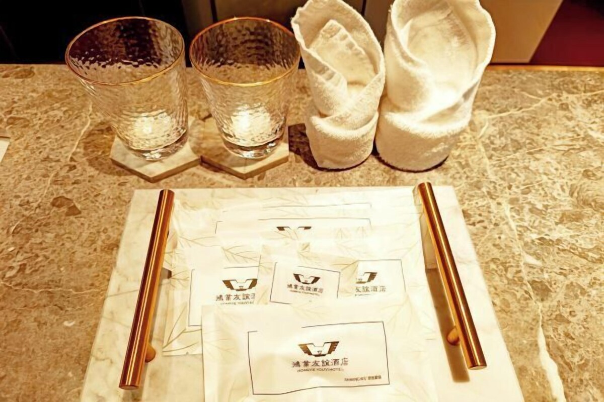A table with two glasses, a pair of chopsticks, and a napkin on a marble surface.