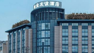 A modern hotel building with a prominent curved top section and multiple windows.