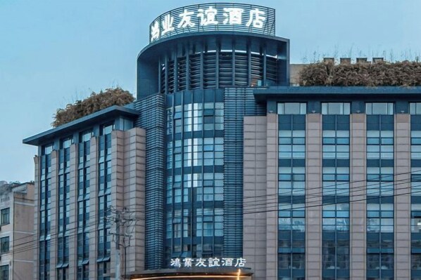 Un moderno edificio de hotel con una sección curva destacada y numerosas ventanas.
