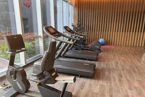 Ein Fitnessstudio mit Trainingsgeräten, darunter Laufbänder und ein Crosstrainer.