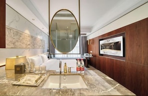 A modern bathroom with a marble sink, a large mirror, a television, and a wooden vanity. - Hongye Youyi Hotel (Yongkang)