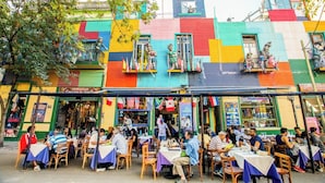 Un edificio colorido con terraza y diversas tiendas.