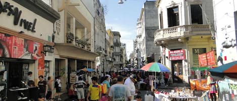 Un mercado callejero bullicioso con varios puestos y tiendas.