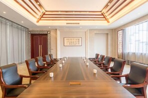 A conference room with a long table and chairs, a decorative wall, and a large window. - SuiningShuiyueHotel (Suining)
