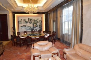 A conference room with a round table, chairs, and a sofa. - SuiningShuiyueHotel (Suining)