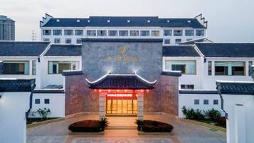 A traditional building with a prominent entrance, a sign with Chinese characters, and a well-maintained courtyard.