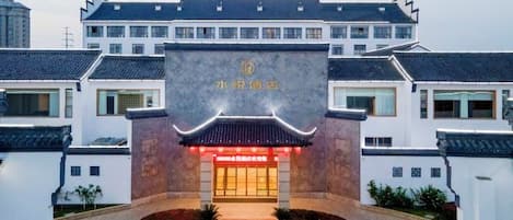 A traditional building with a prominent entrance, a sign with Chinese characters, and a well-maintained courtyard.