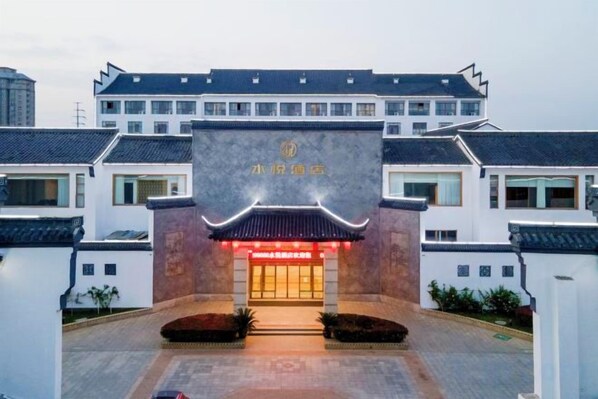 A traditional building with a prominent entrance, a sign with Chinese characters, and a well-maintained courtyard. - SuiningShuiyueHotel (Suining)
