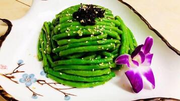 A plate of green vegetable dish with a decorative flower.