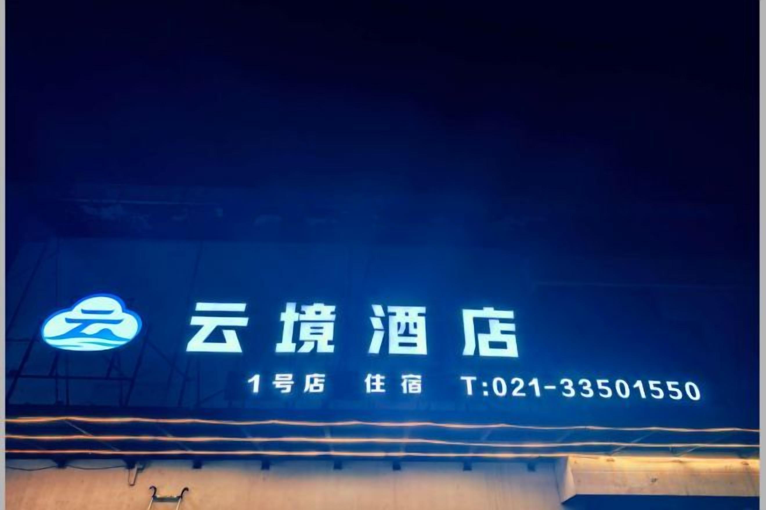 Placa de hotel com o nome '云境酒店' e o número de telefone 'T:021-33501550'.