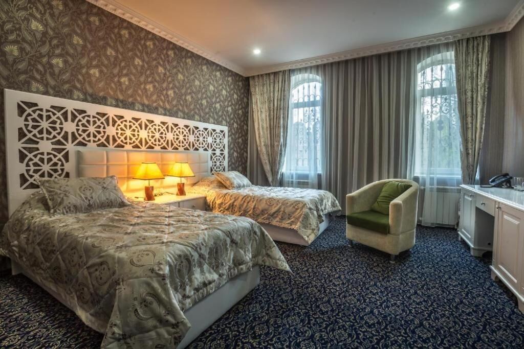 Ein Hotelzimmer mit zwei Betten, einem Schreibtisch, einem Stuhl und einer Wandverkleidung.