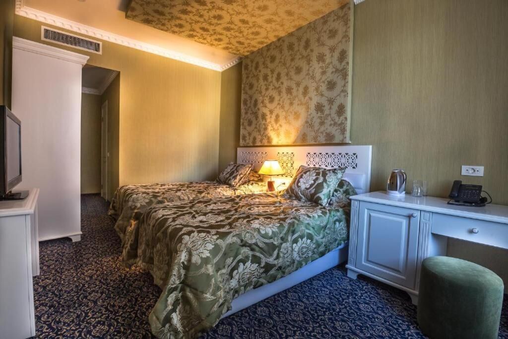 Une chambre d’hôtel équipée d’un lit, d’une table de chevet, d’une lampe et d’un bureau avec un téléphone.