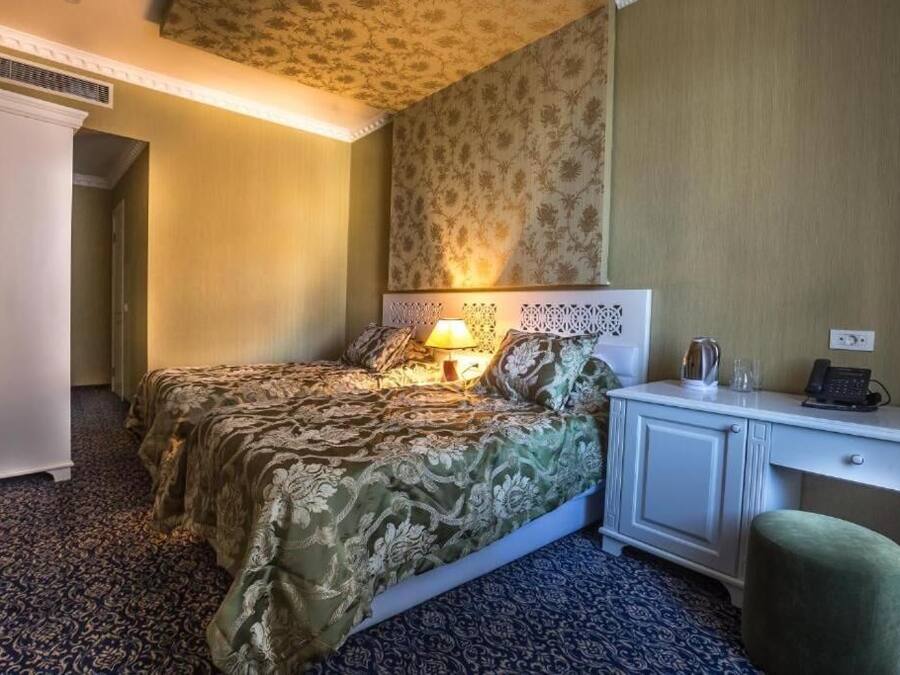 Une chambre d’hôtel équipée d’un lit, d’une table de chevet, d’une lampe et d’un bureau avec un téléphone.