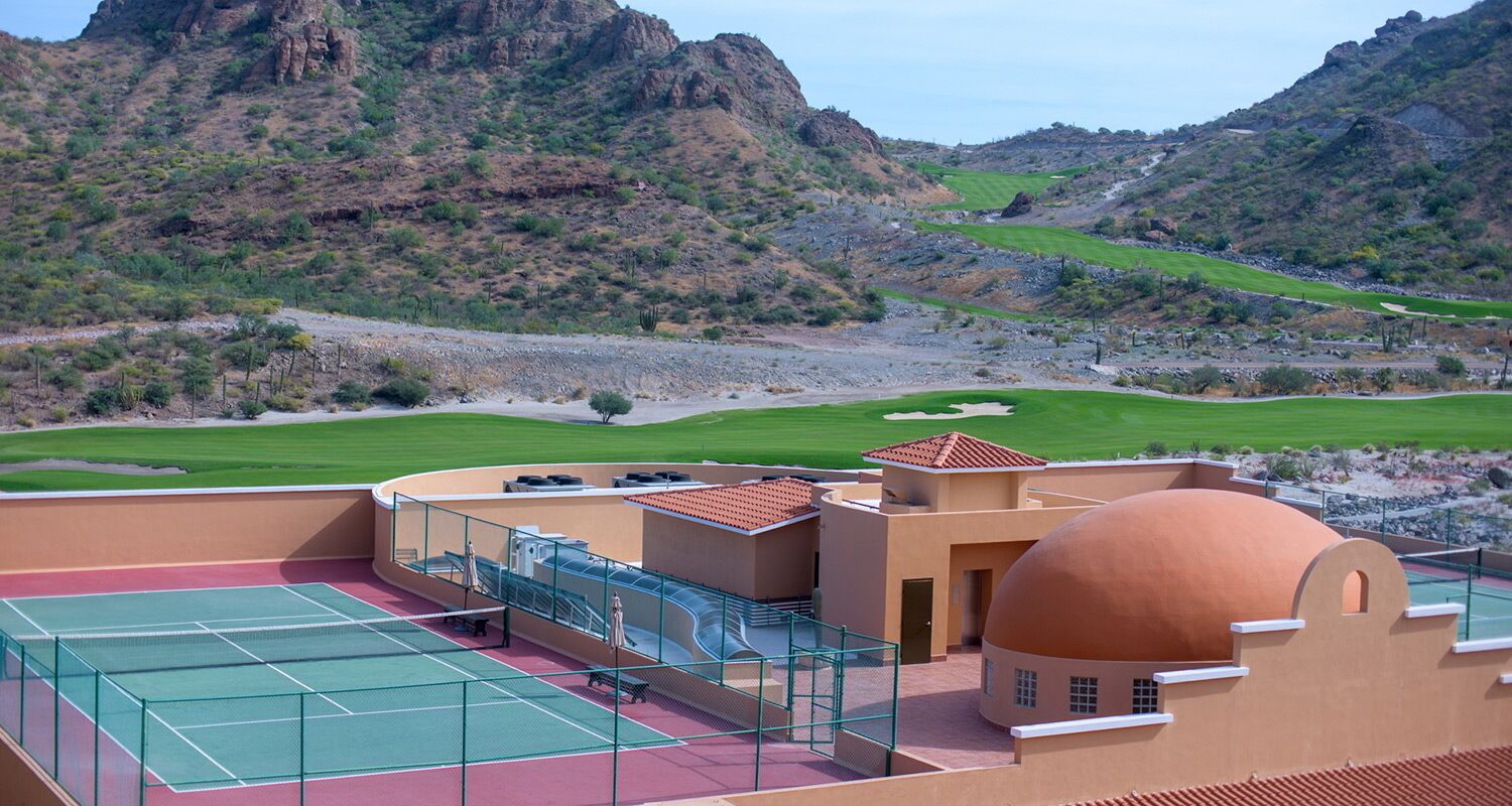 Ein Tennisplatz mit Blick auf eine gebirgige Landschaft.
